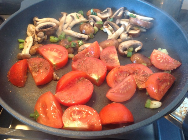 Adding tomatoes and Jerk seasoning to the mushies and shallots.